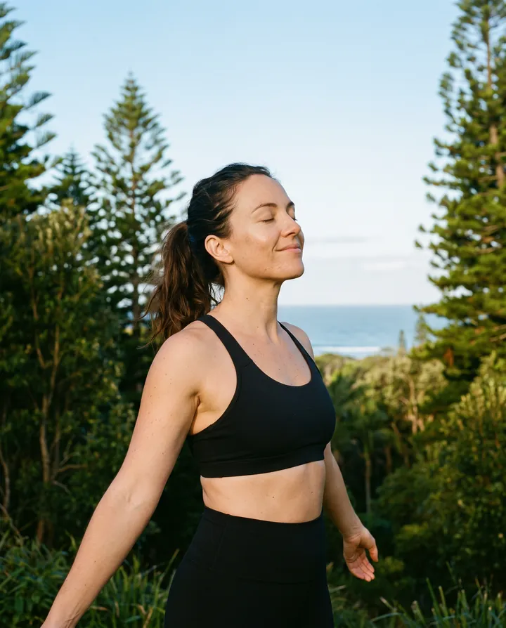 Woman in workout clothes breathing fresh air outdoors at sunrise