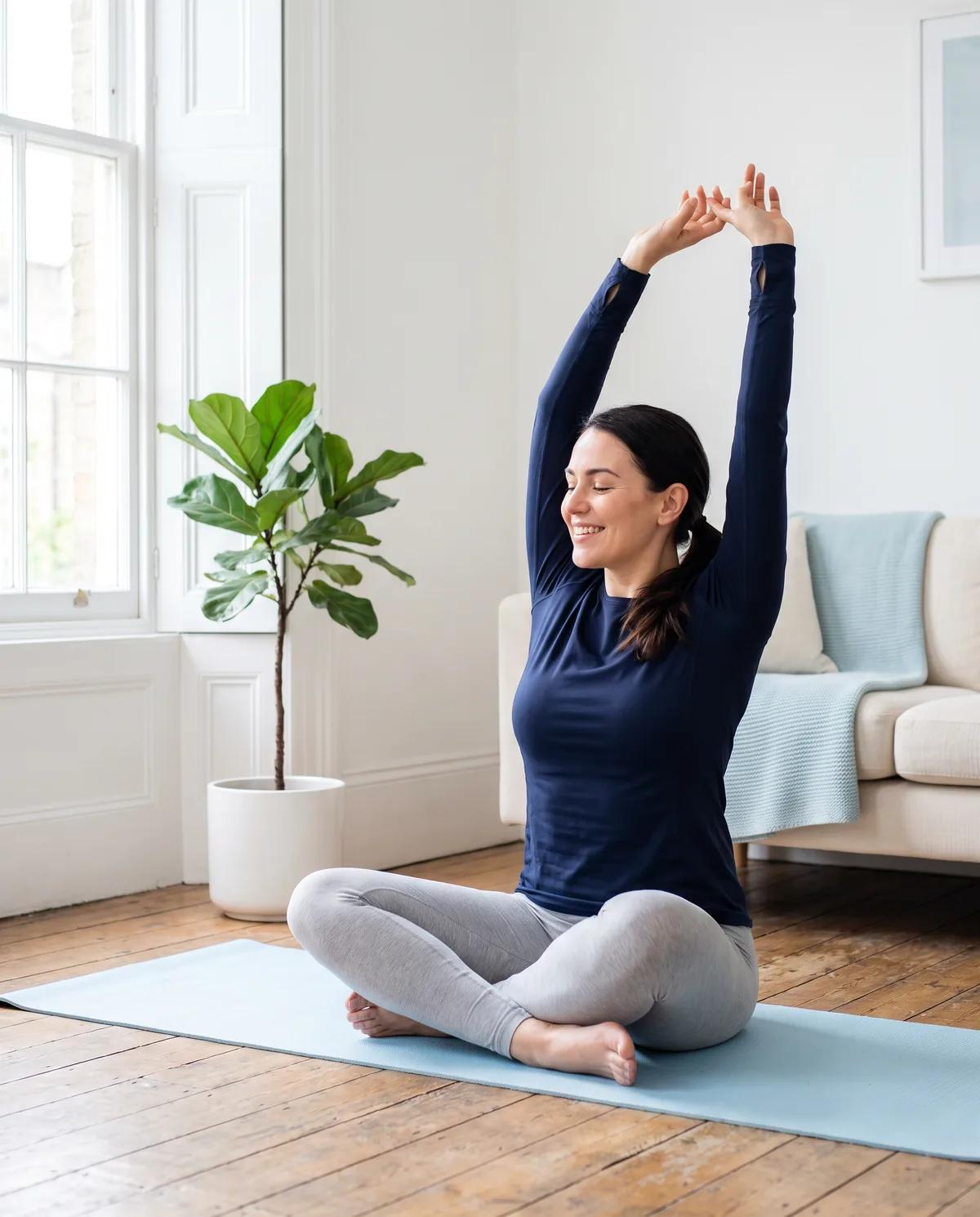 Woman stretching with her arms raised in a bright living room