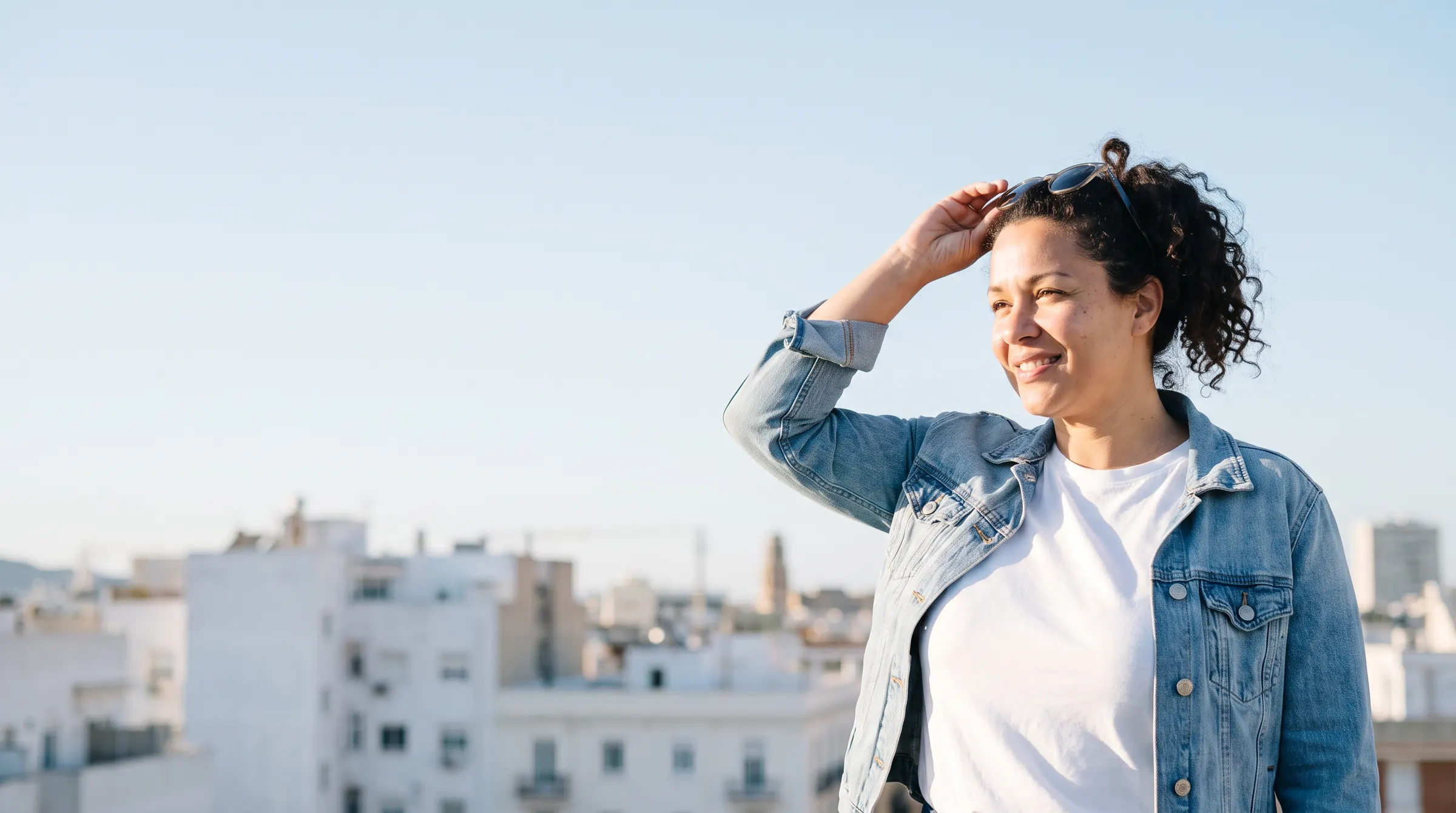 Woman smiling in the morning sun on a rooftop terrace